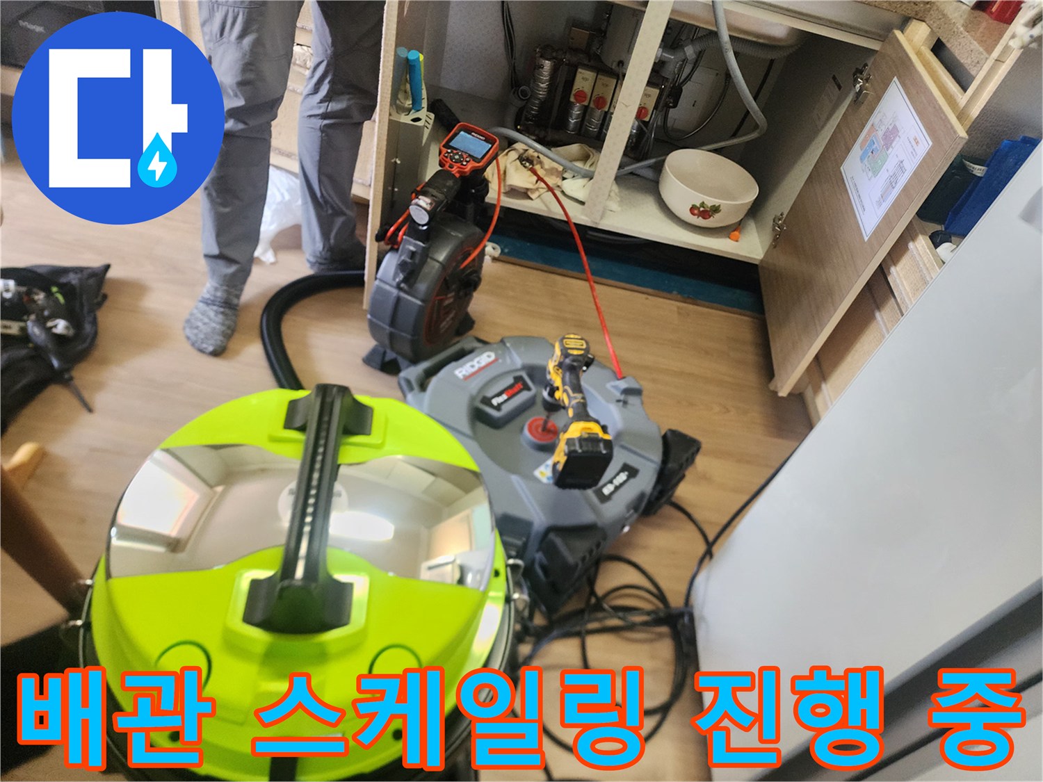 싱크대 하부장 작업 공간에 배치된 배관 청소용 장비들