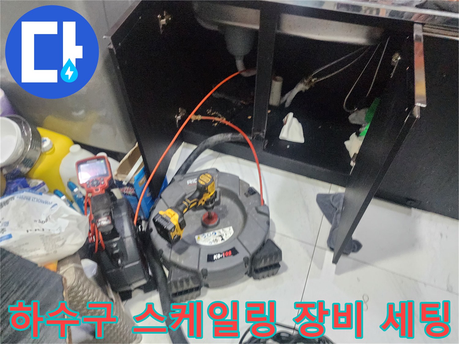 싱크대 하부 배관 청소를 위한 전동 드릴과 내시경 카메라 연결 상태