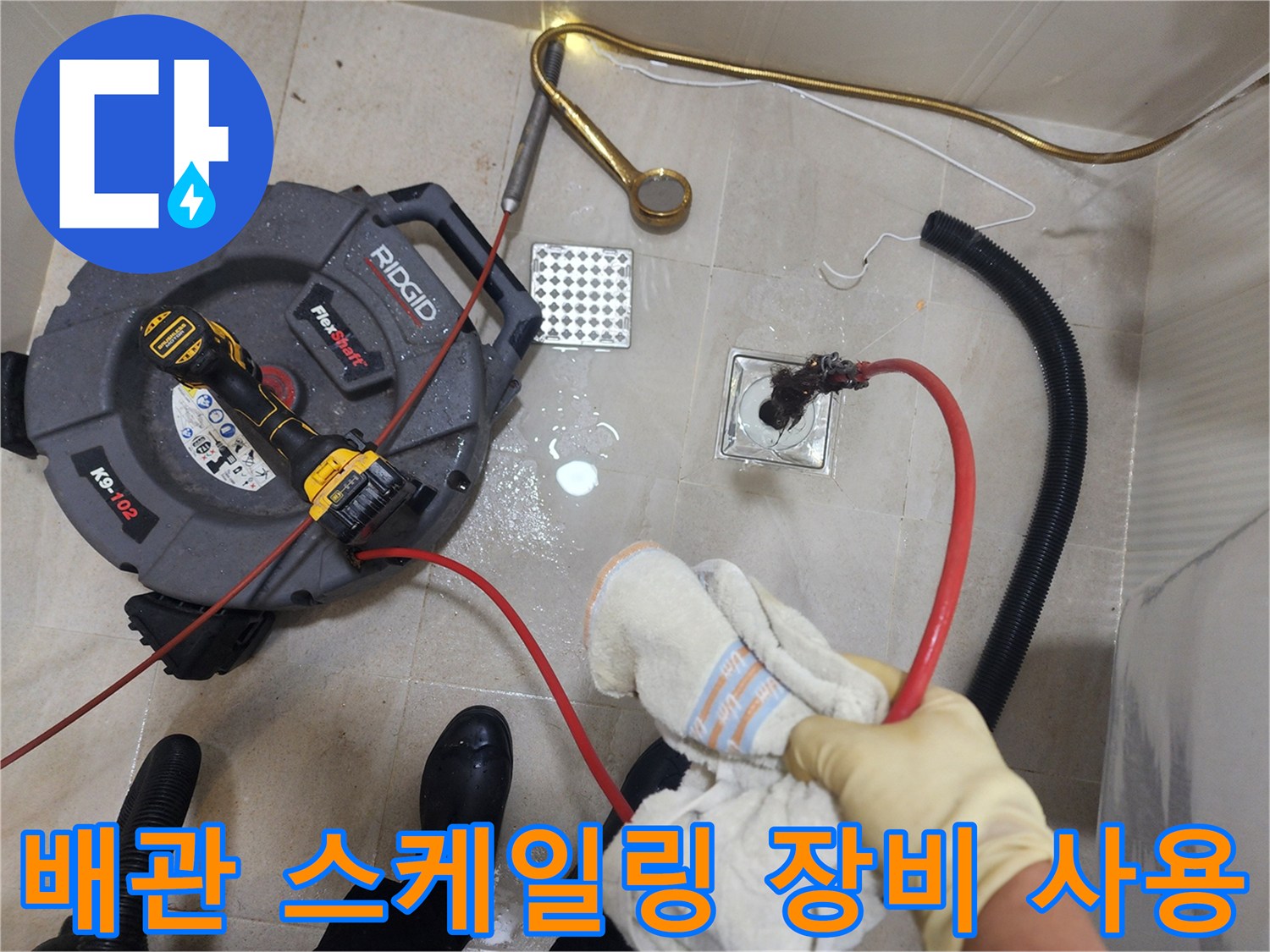 빨간색 케이블이 연결된 리지드 스케일링 장비와 화장실 바닥 배수구 부위