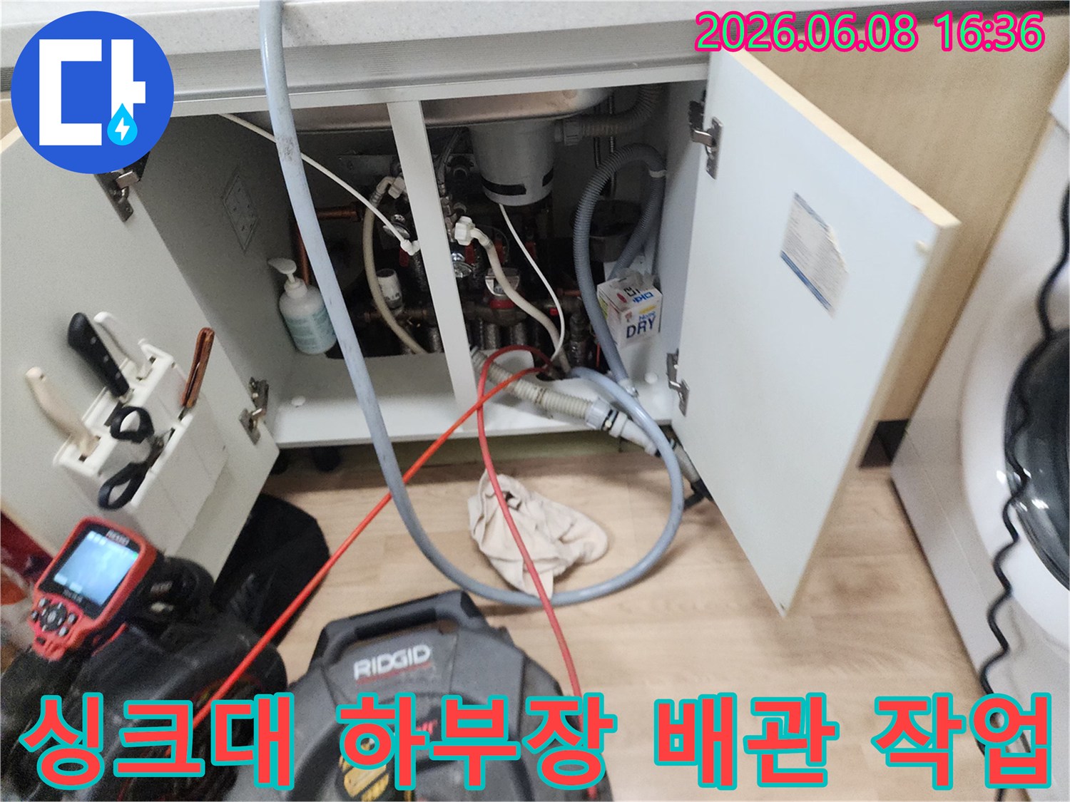 남양주 평내동 싱크대 하부장 내부의 복잡한 배관과 스케일링 장비 모습