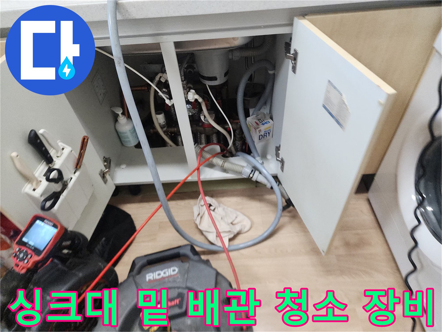 싱크대 아래 공간에 설치된 스케일링 장비와 연결된 배관들