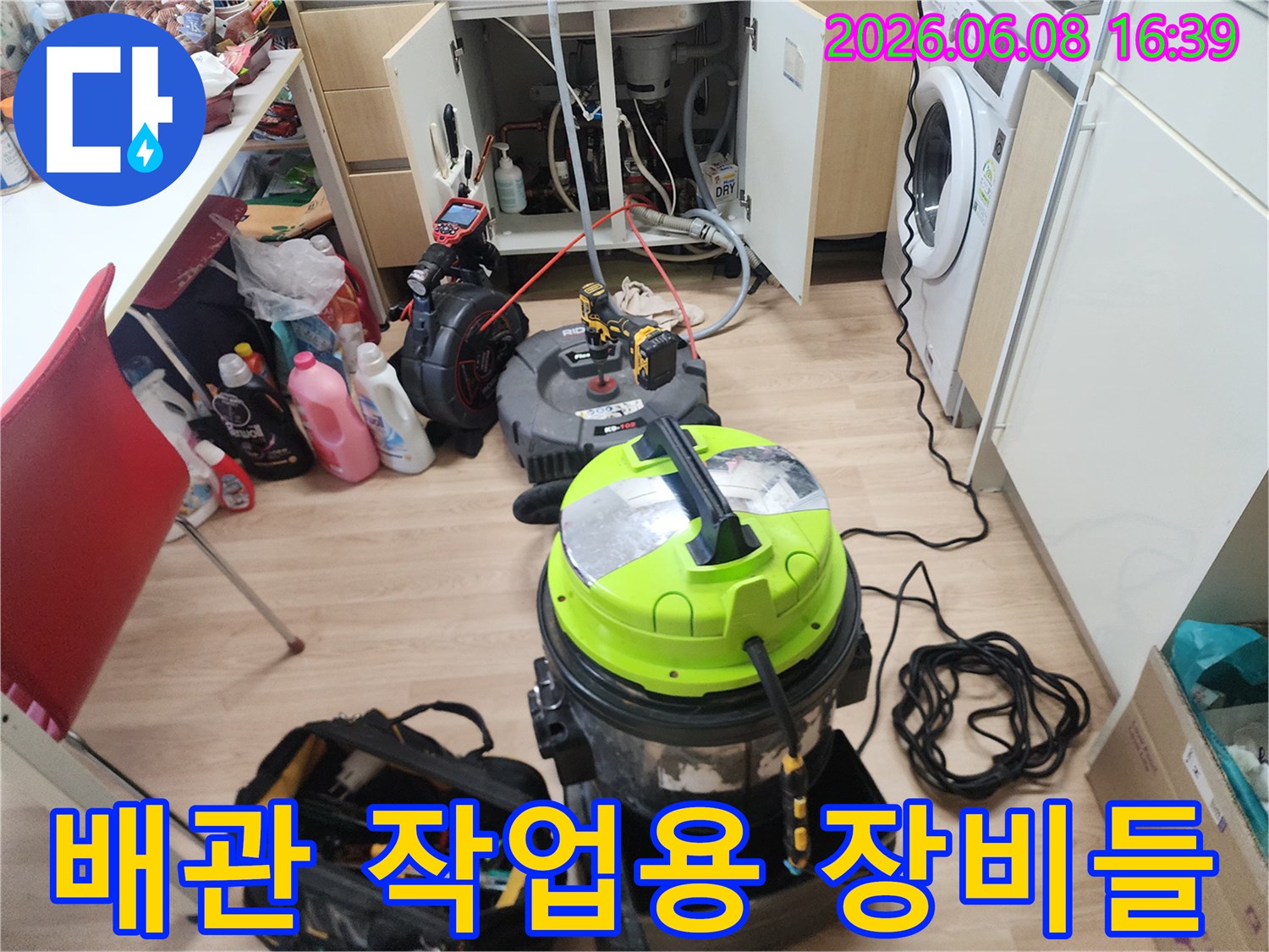 싱크대 하단 배관 세척을 위해 배치된 석션기와 공구함