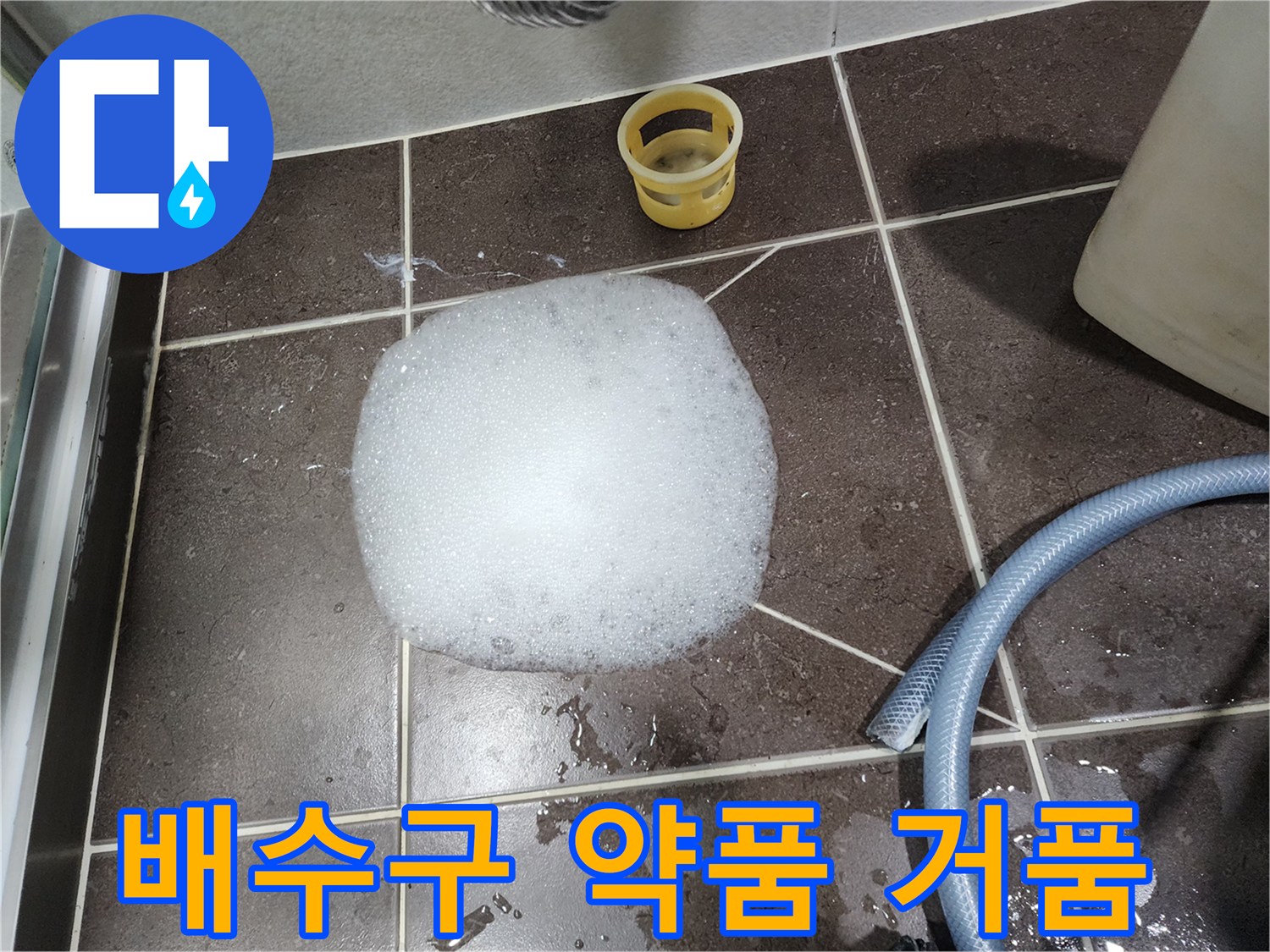 어두운색 타일 위에 하얀 거품이 덩어리져 있는 모습