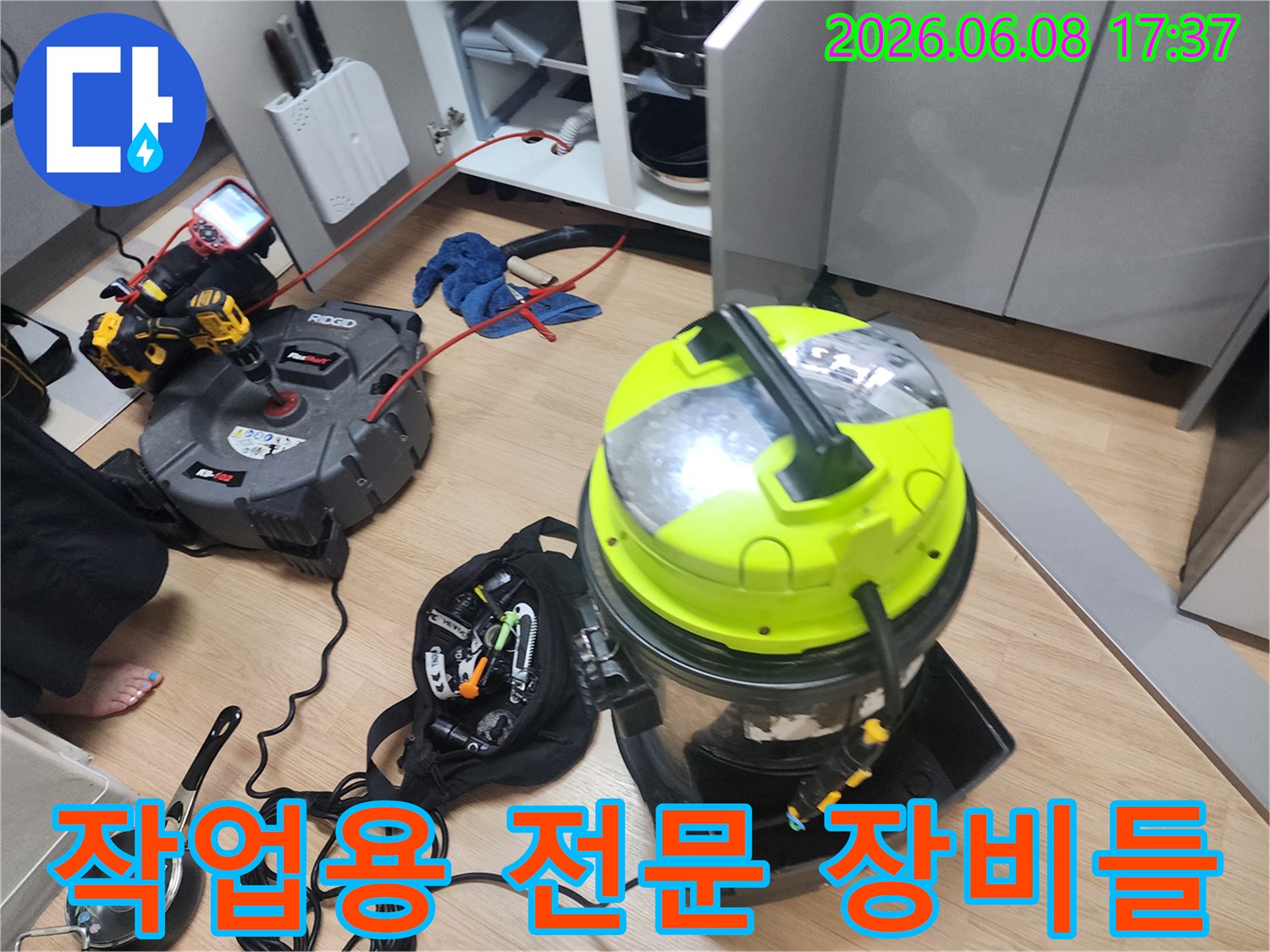 싱크대 하단 배관 작업을 위해 배치된 석션기와 전동 공구