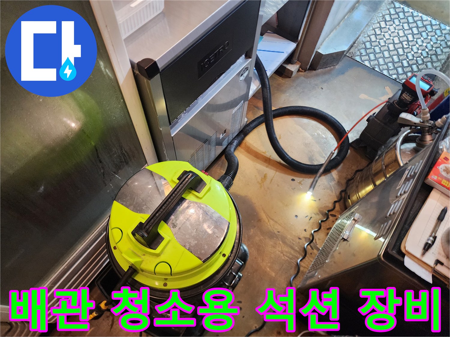 바닥 배수구의 이물질 제거를 위해 설치된 산업용 석션기와 연결 호스입니다.