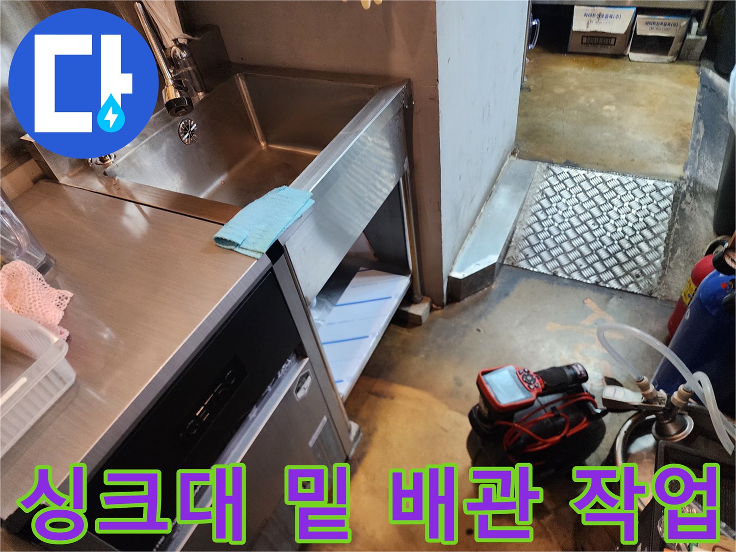주방 싱크대 하부와 바닥에 설치된 전문 배관 청소 장비