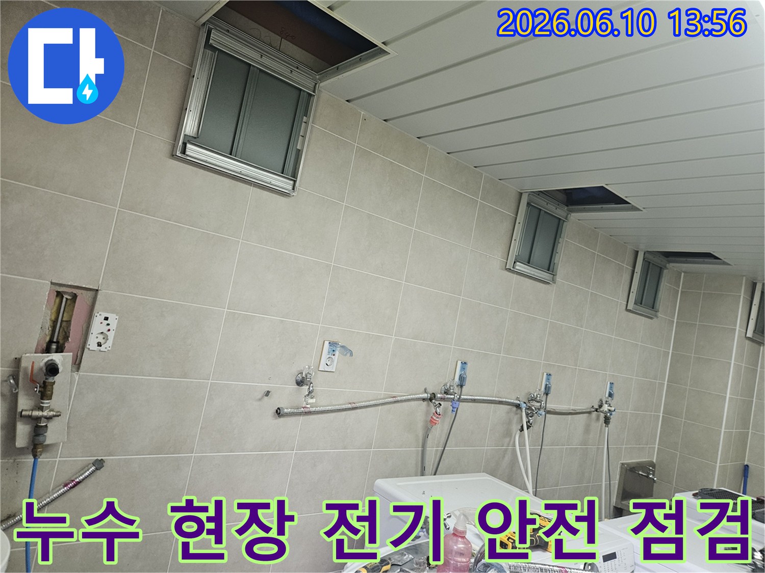 세탁기 옆 벽면에 보이는 전기 콘센트와-누수 위험 요소를 함께 점검하는-안전 우선 작업 현장