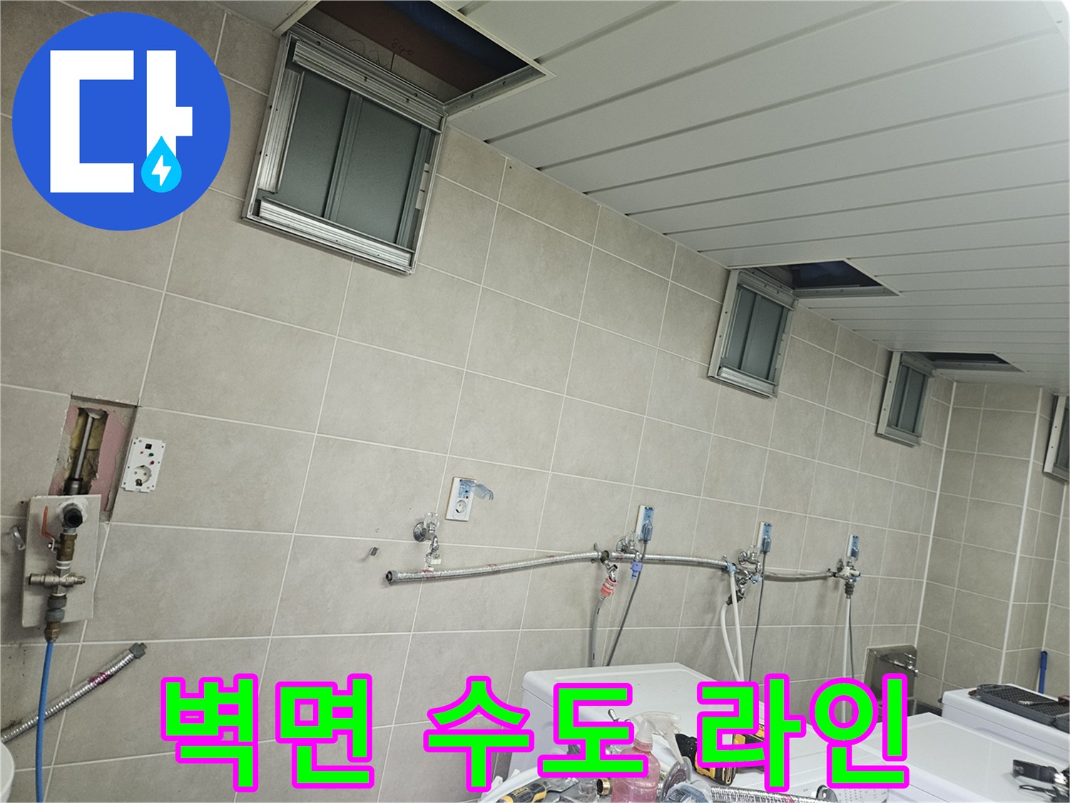 세탁실 벽면에 설치된 은색 수도 배관 및 밸브