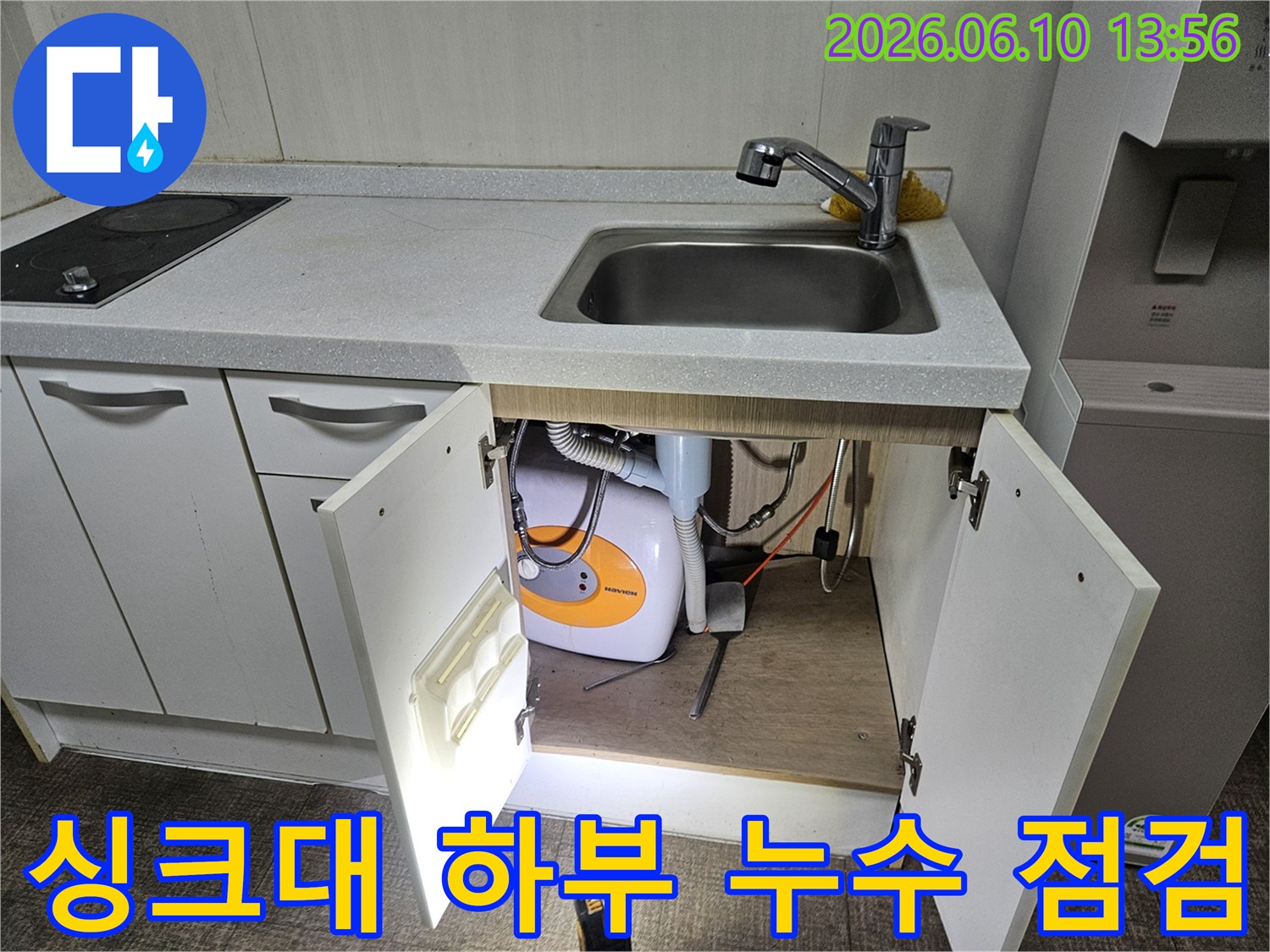 싱크대 밑 물고임의 원인을 찾기 위해-배관과 온수기를-세밀하게 점검하고 있습니다.