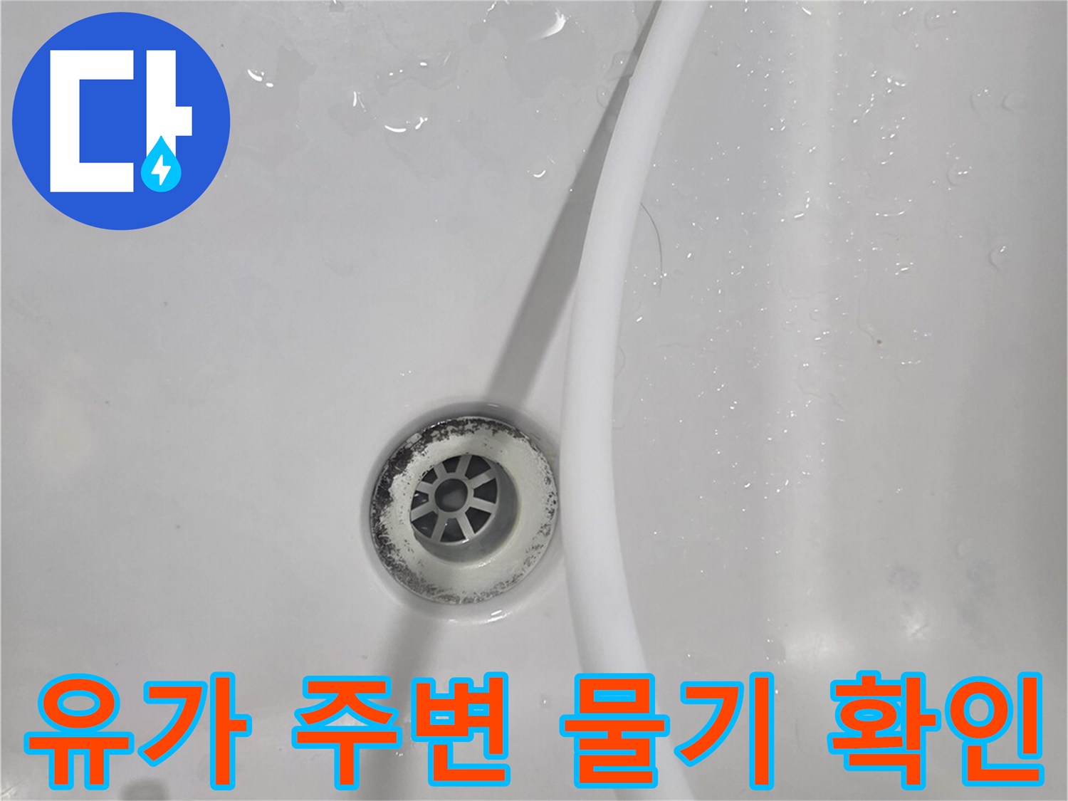 배수구 주위의 젖은 타일 표면을 클로즈업한 이미지입니다.