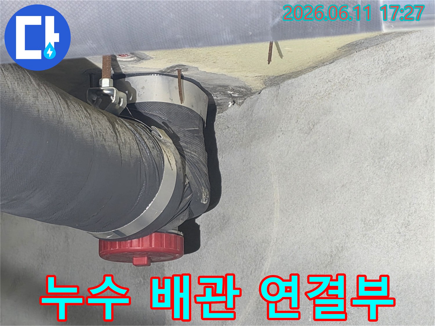 오래된 아파트 배관의 연결부에서 발견된 물샘 현상-전문가가 누수 원인을 분석하는 모습