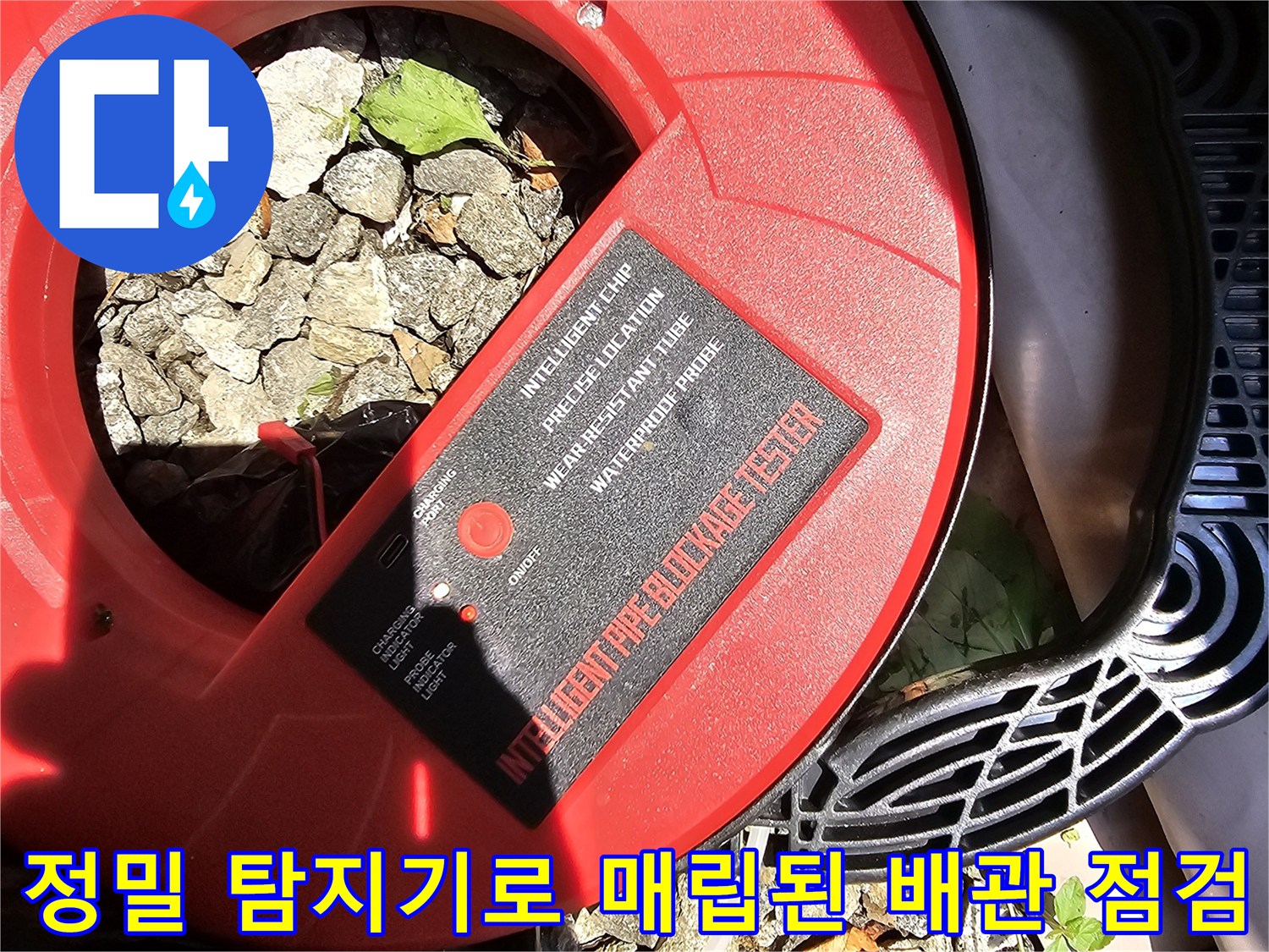 전문 탐지기를 사용하여 지면 아래 숨겨진 파이프의 이상 부위를 찾아내는 장면