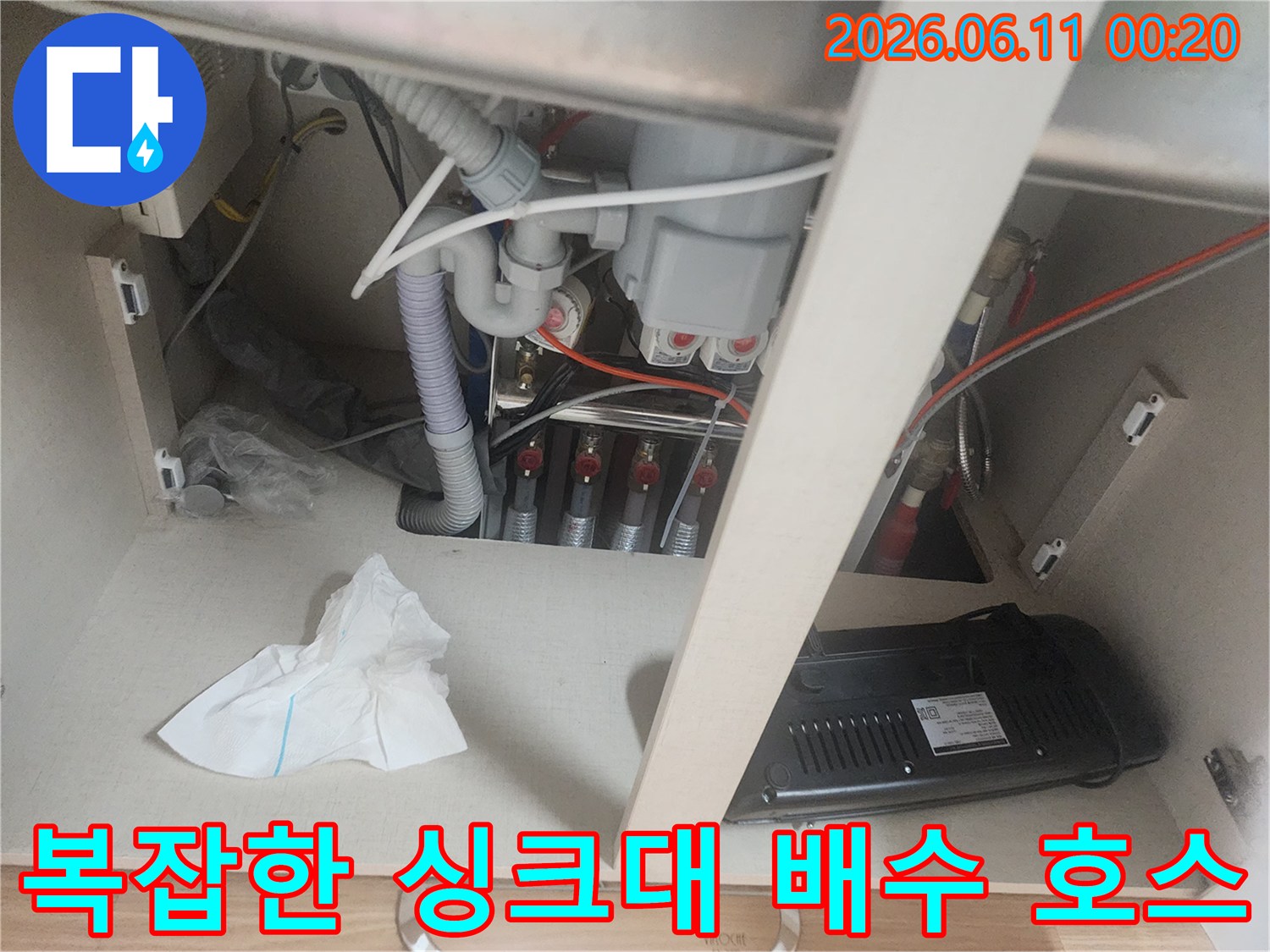 싱크대 하부장 내부의 굴곡진 배수관과 연결 장치들