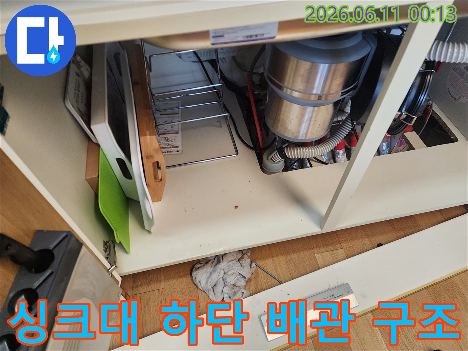 싱크대 하부장 안쪽의 배수 호스와 금속관 연결 부위 사진