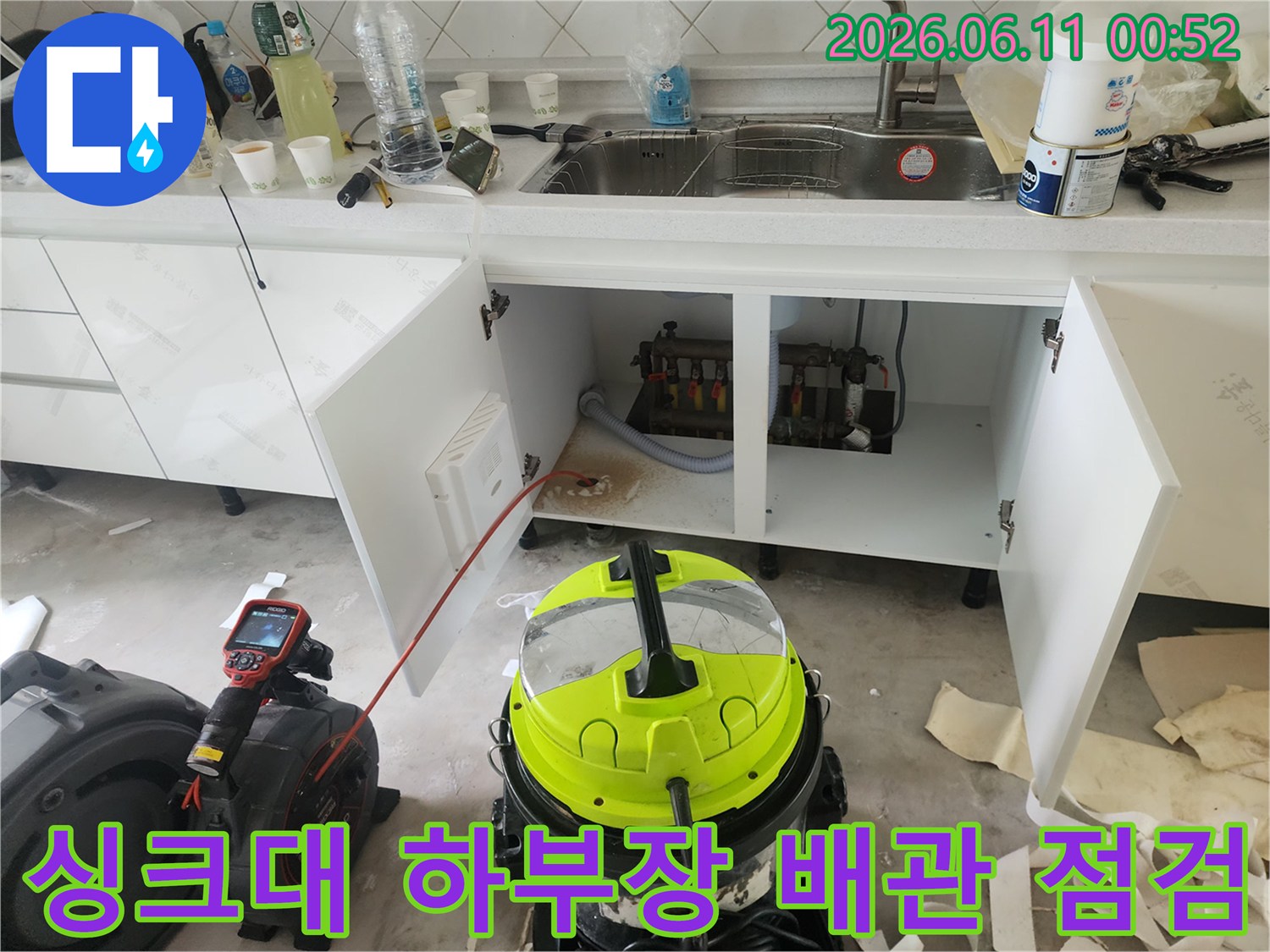 은평구 불광동 싱크대 하부장 내부의 노출된 배관과 작업용 석션 장비 모습입니다.