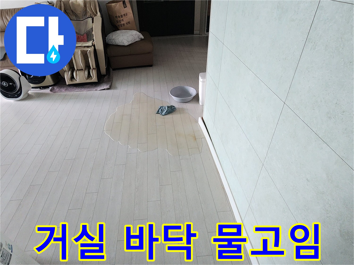 거실 마루에 물이 흥건하게 고여있는-누수 발생 상황을 보여주는-사진입니다