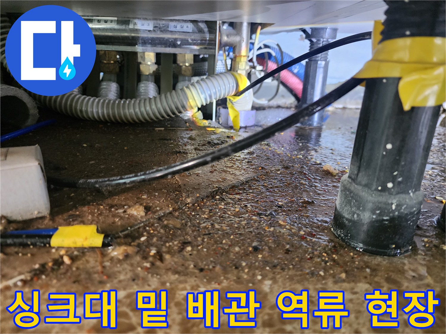 싱크대 하부 바닥의 오염된 물과 슬러지가 고여 있는 장면