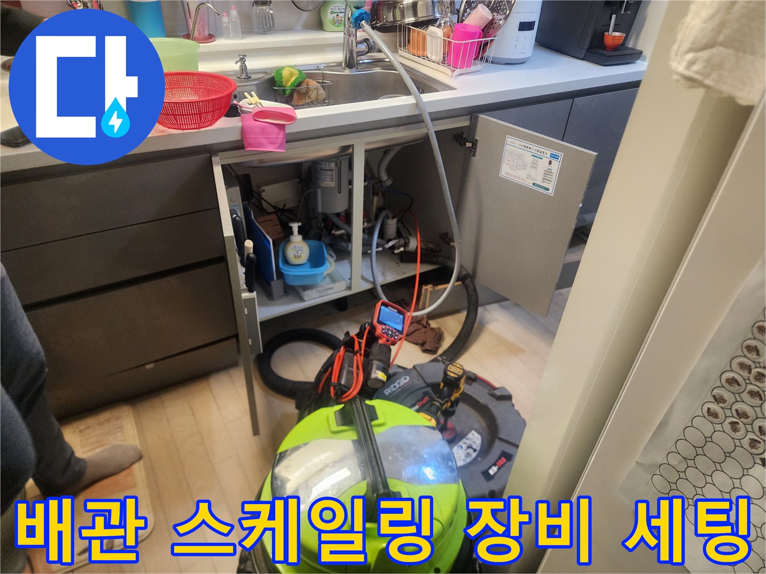 싱크대 하부장 밑에 배치된 습식 석션기와 배관 청소용 장비입니다.