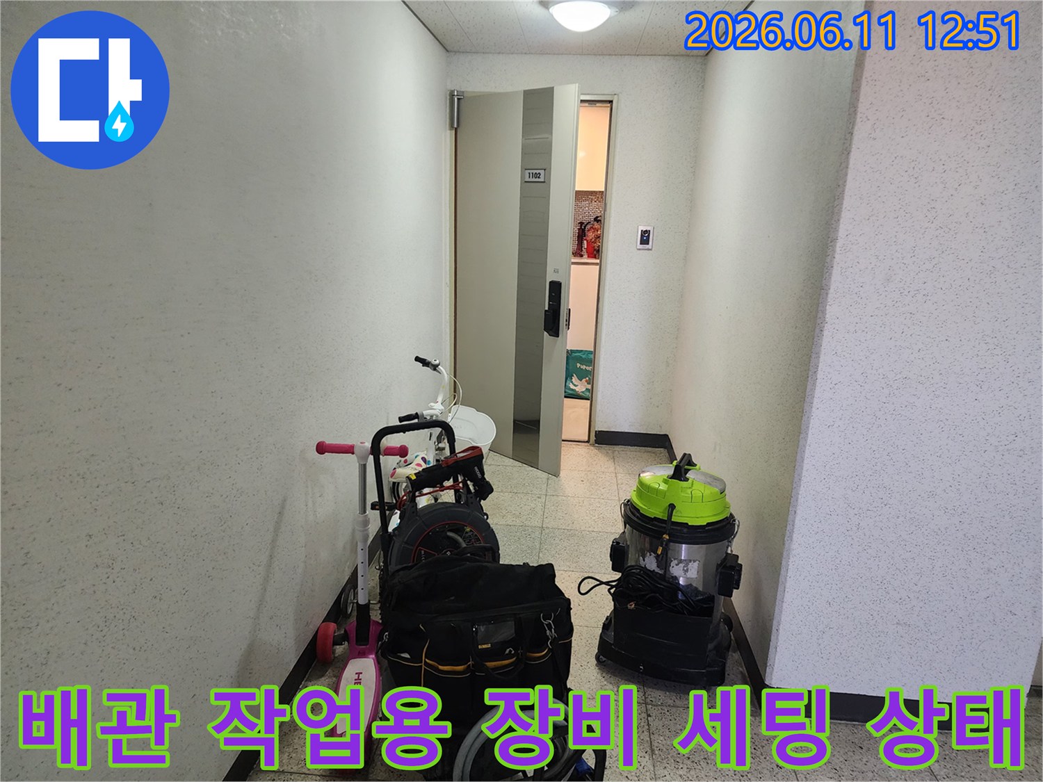 복도 바닥에 준비된 배관 청소 전용 흡입기와 공구함