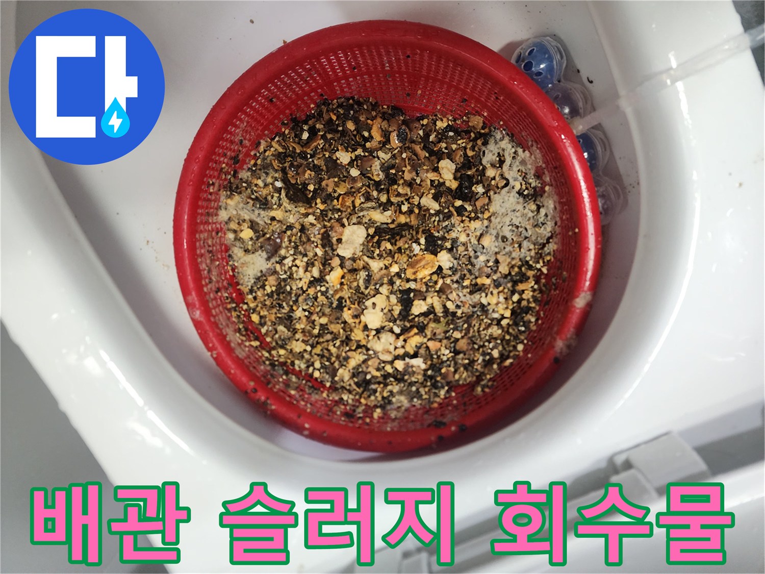 붉은색 채에 걸러진 배관 슬러지 덩어리들