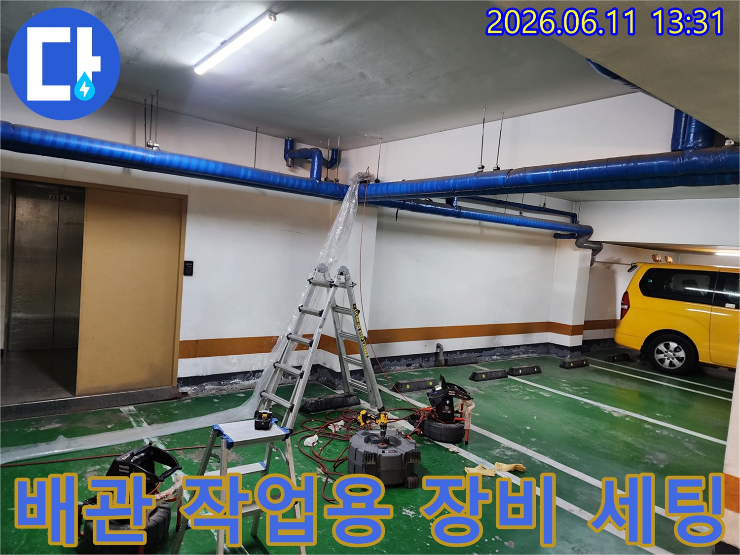 사다리와 고압 세척기가 배치된 지하 주차장 배관 작업장