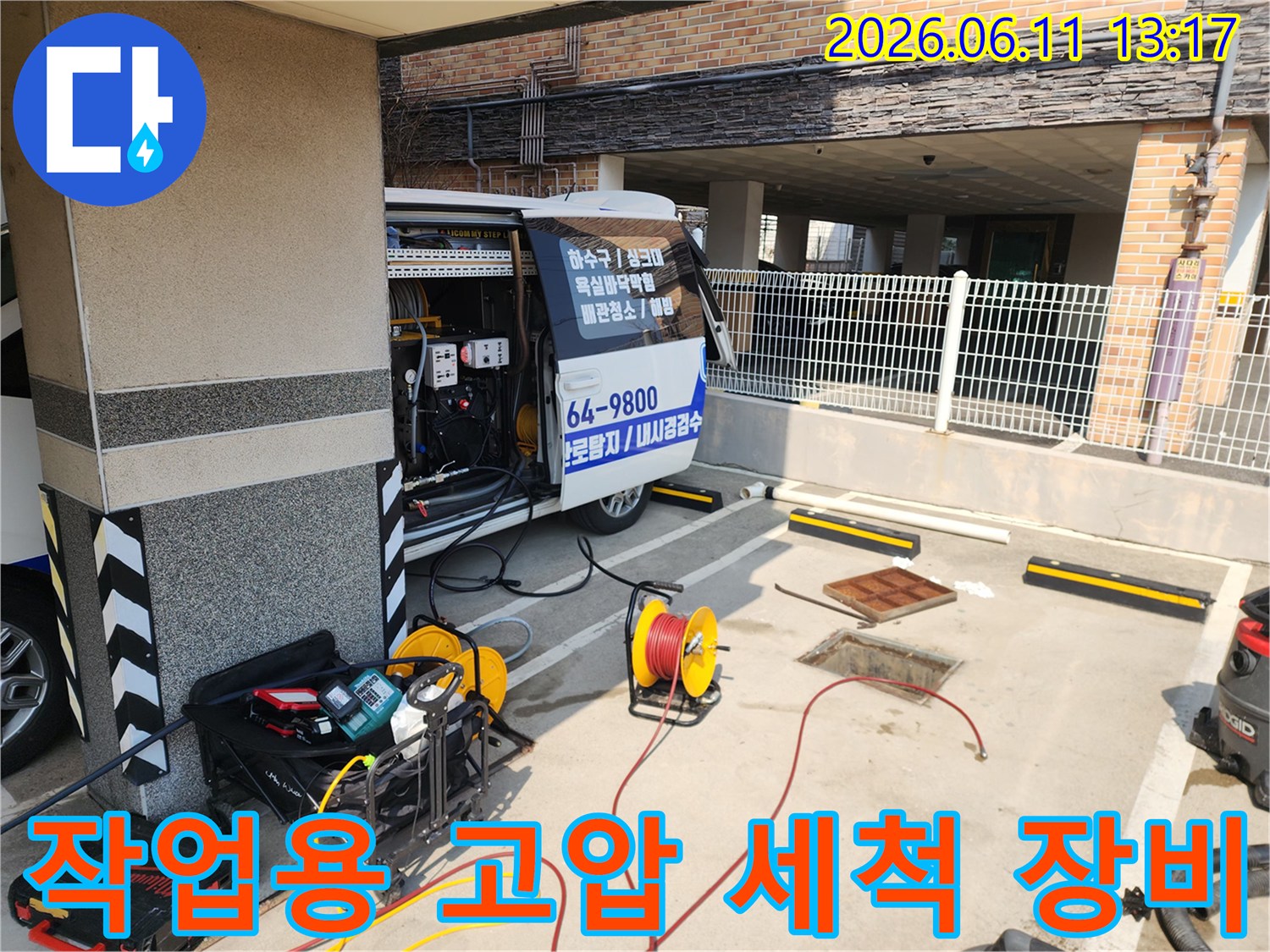 트럭 옆에 설치된 배관 청소용 고압 세척기와 노란색 호스 릴