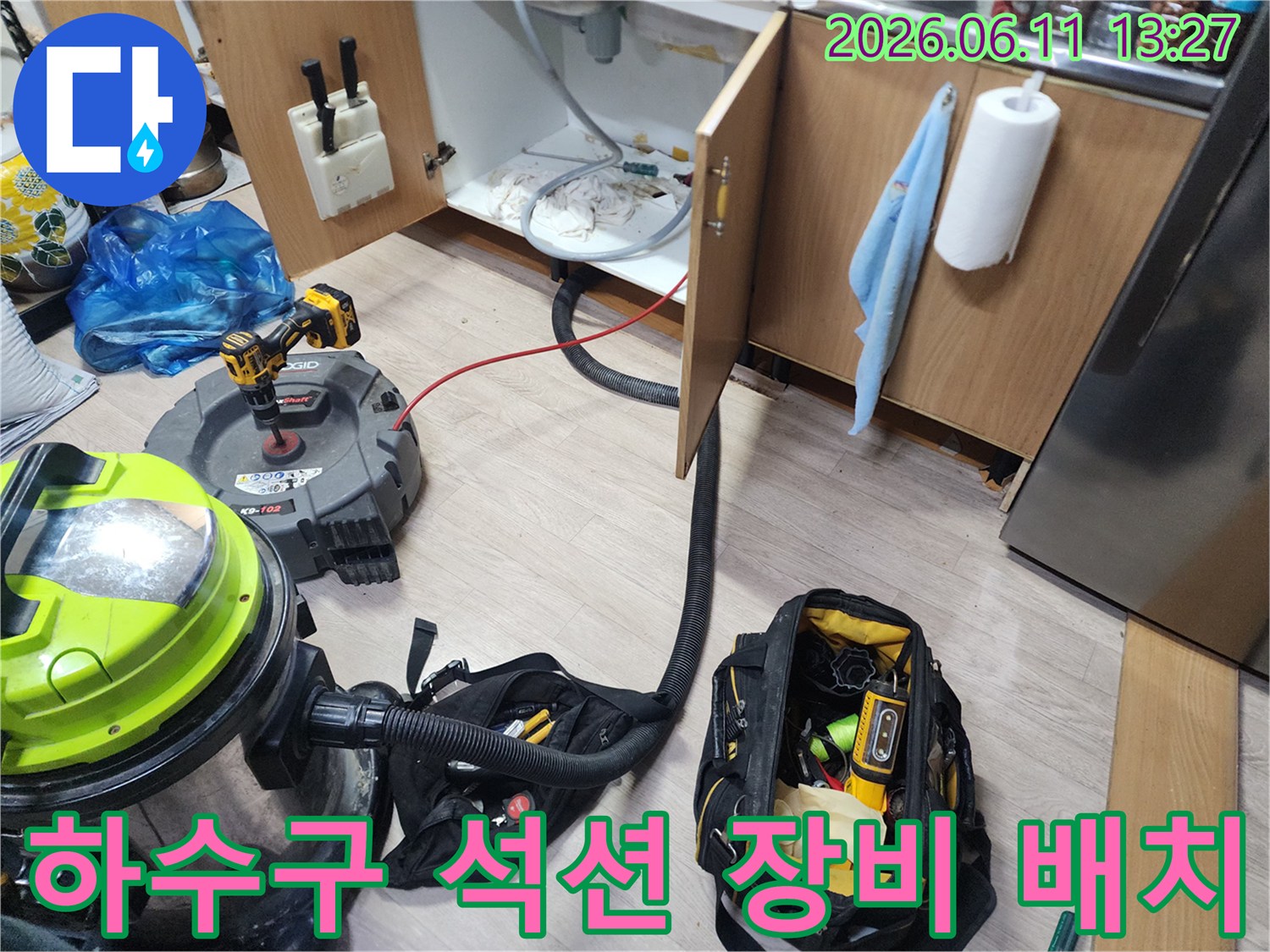 싱크대 하단 배관의 이물질 흡입을 위해 강력한 석션기를 설치한 장면입니다.
