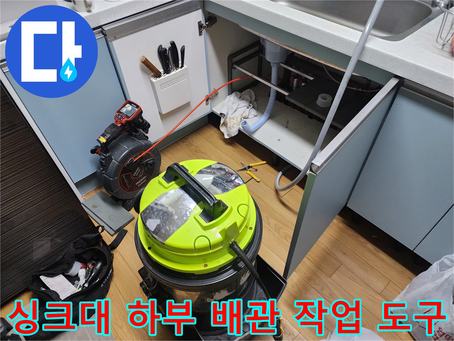 주방 싱크대 밑 배관 청소를 위한 석션 장비와 주변 모습