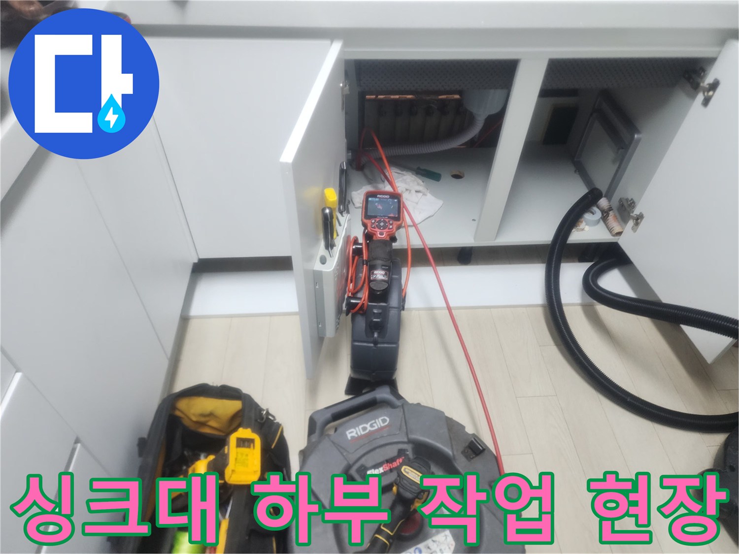 남양주 평내동 싱크대 하부장에서 진행 중인 배관 스케일링 장비와 흡입 호스 모습