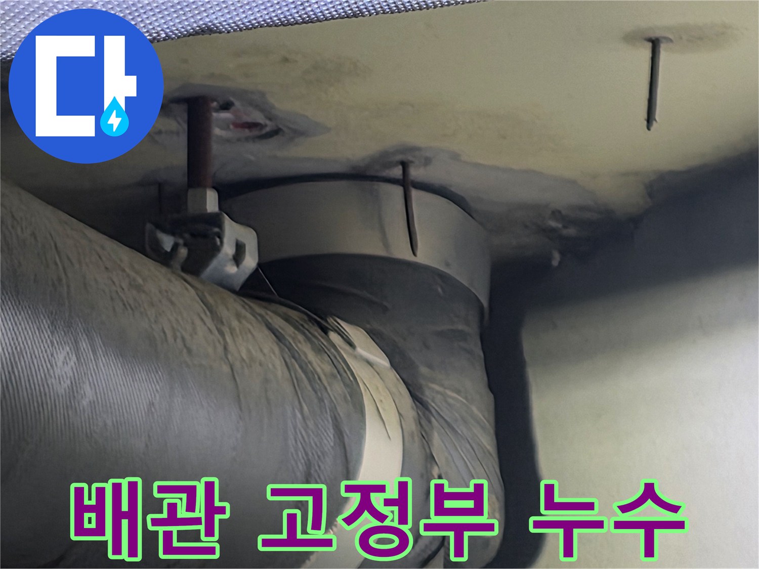 천장 배관 고정부 주변에 나타난 습기와 누수 흔적-이는 배관 연결부의 문제일 수 있습니다