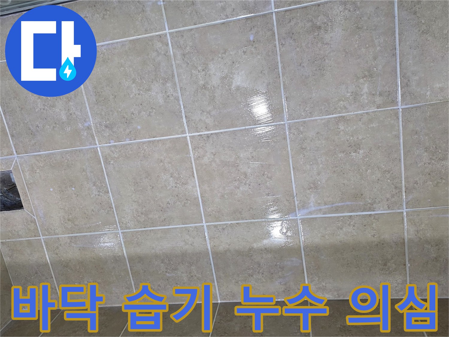 타일 바닥에 넓게 퍼진 습기는 누수가 진행되고 있음을 시사하며-전문적인 탐지가 필요한 상황입니다