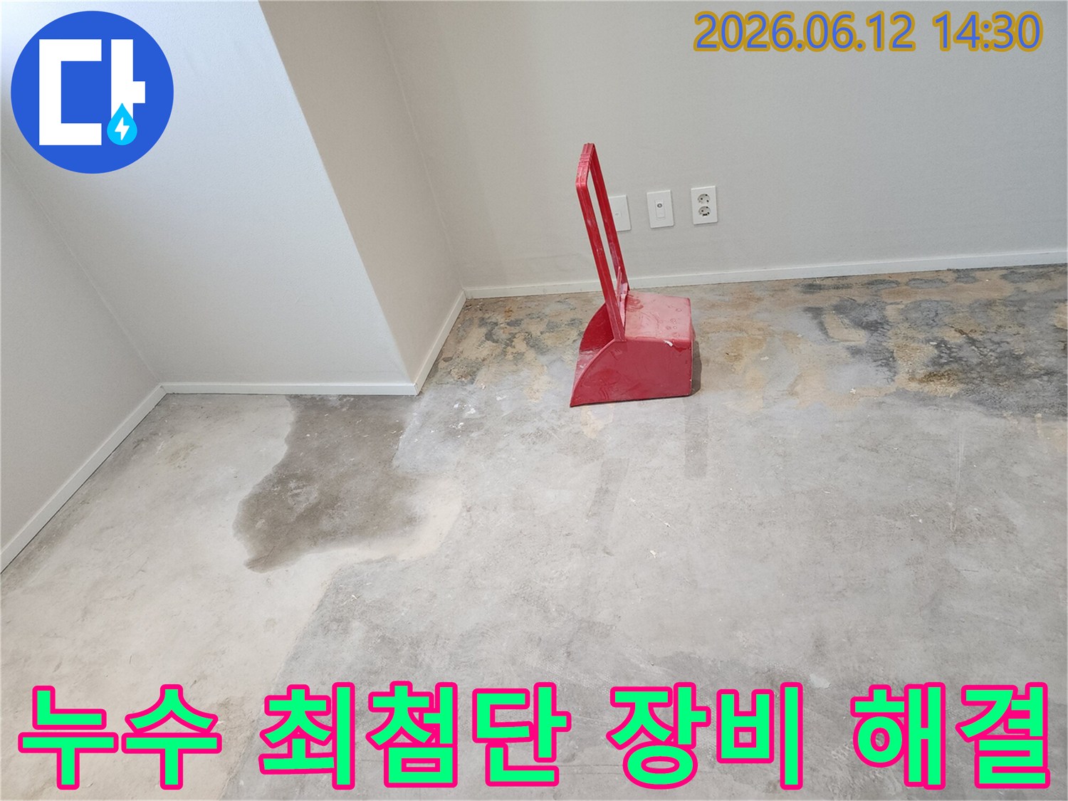 누수-현장에서-콘크리트-바닥이-젖어있고-빨간색-청소-도구가-놓여있는-모습