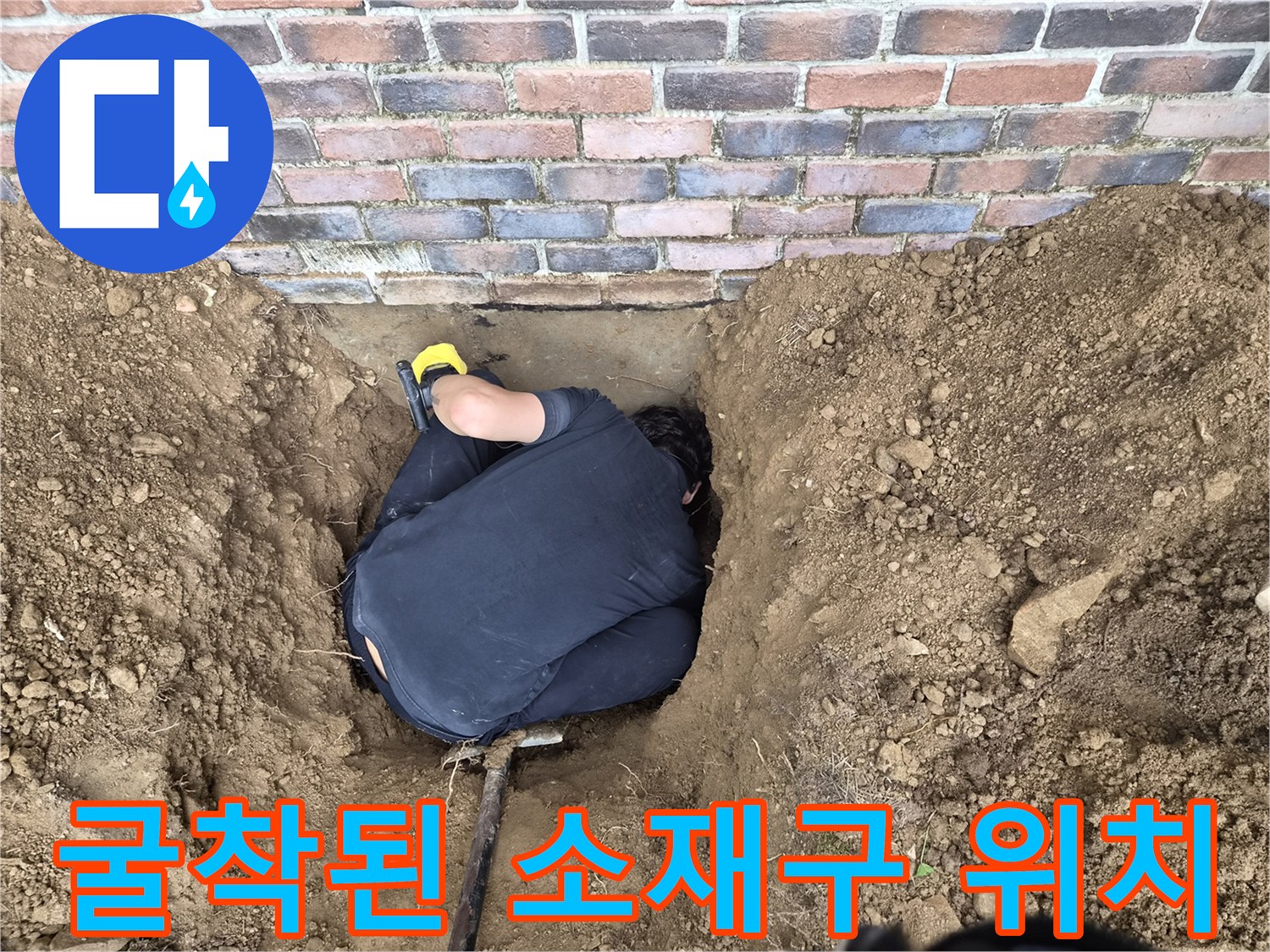 흙으로 파헤쳐진-벽돌 외벽 아래 매립 배관 확인 작업