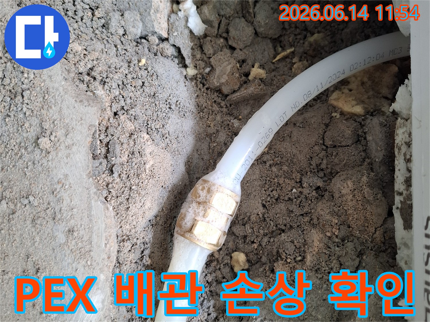 흙 속에 노출된-PEX 수도 배관의-손상된 연결 부위를-확인하고 있는-누수 공사 현장 사진입니다
