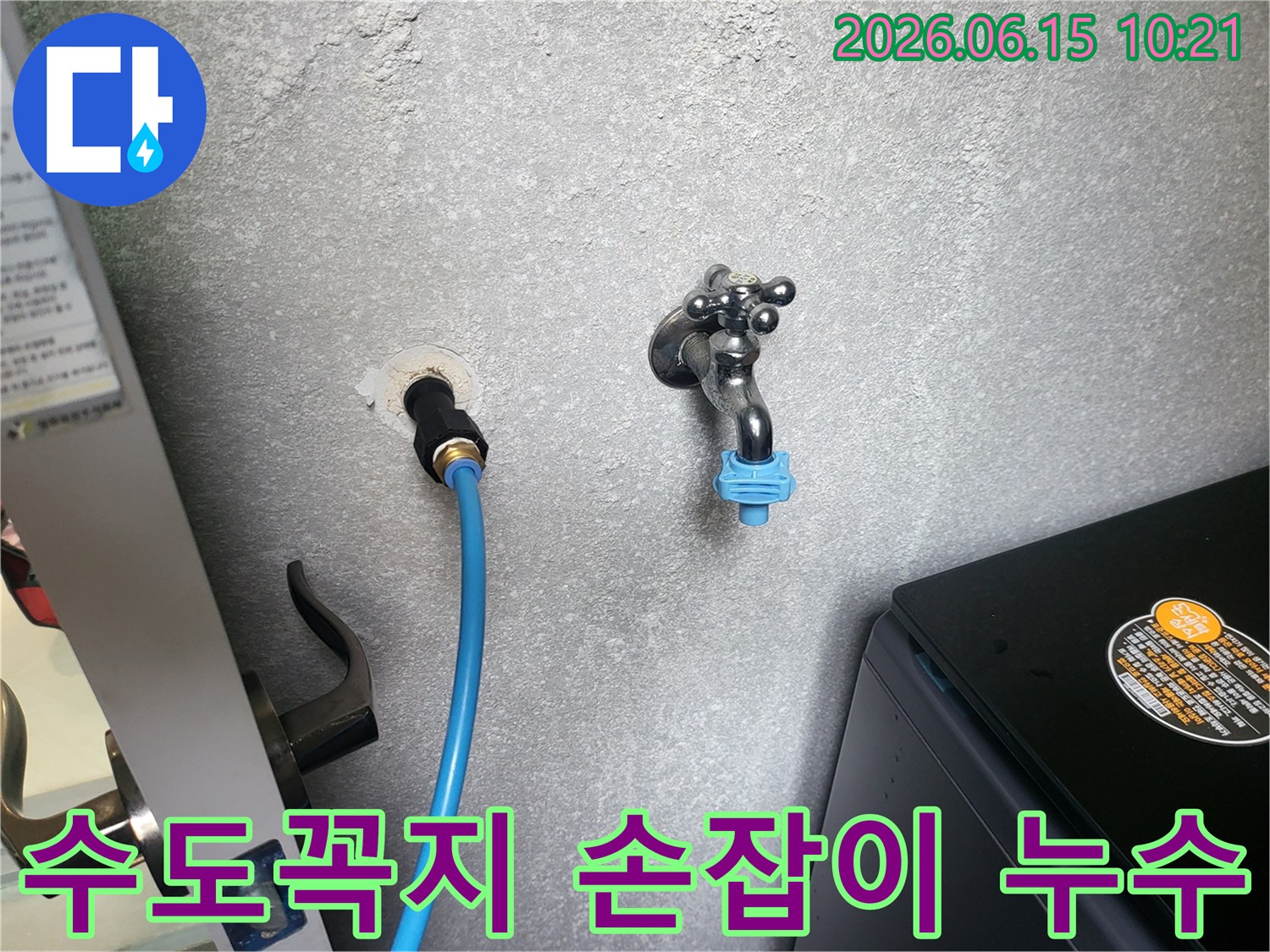 회색 벽에 설치된 수도꼭지-손잡이 부분에서 발생한 미세 누수를 점검하는 모습