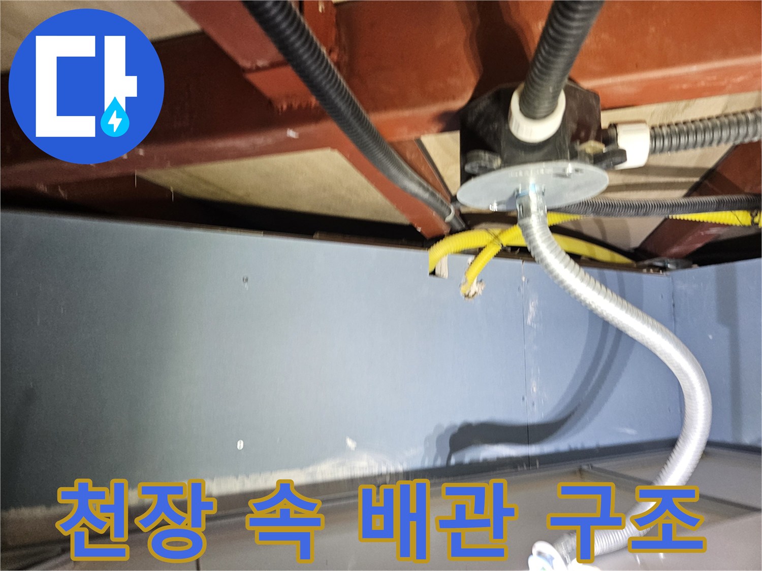 천장 슬래브 아래 설치된 은색 자재의 유연한 배관과 검은색 전선관