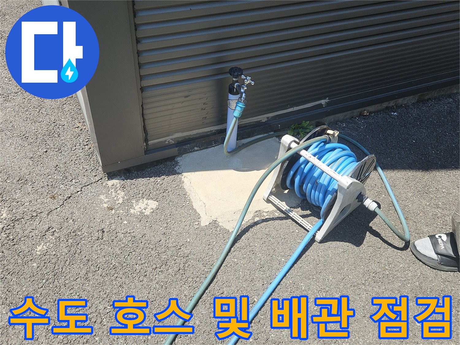 파란색 호스 릴과 외부 수도 연결 부위의 근접 촬영