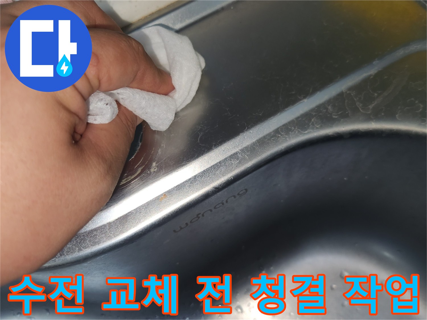 싱크대 상판의 수전 구멍 주변을- 젖은 천으로 꼼꼼히 닦아내는 손의 모습입니다