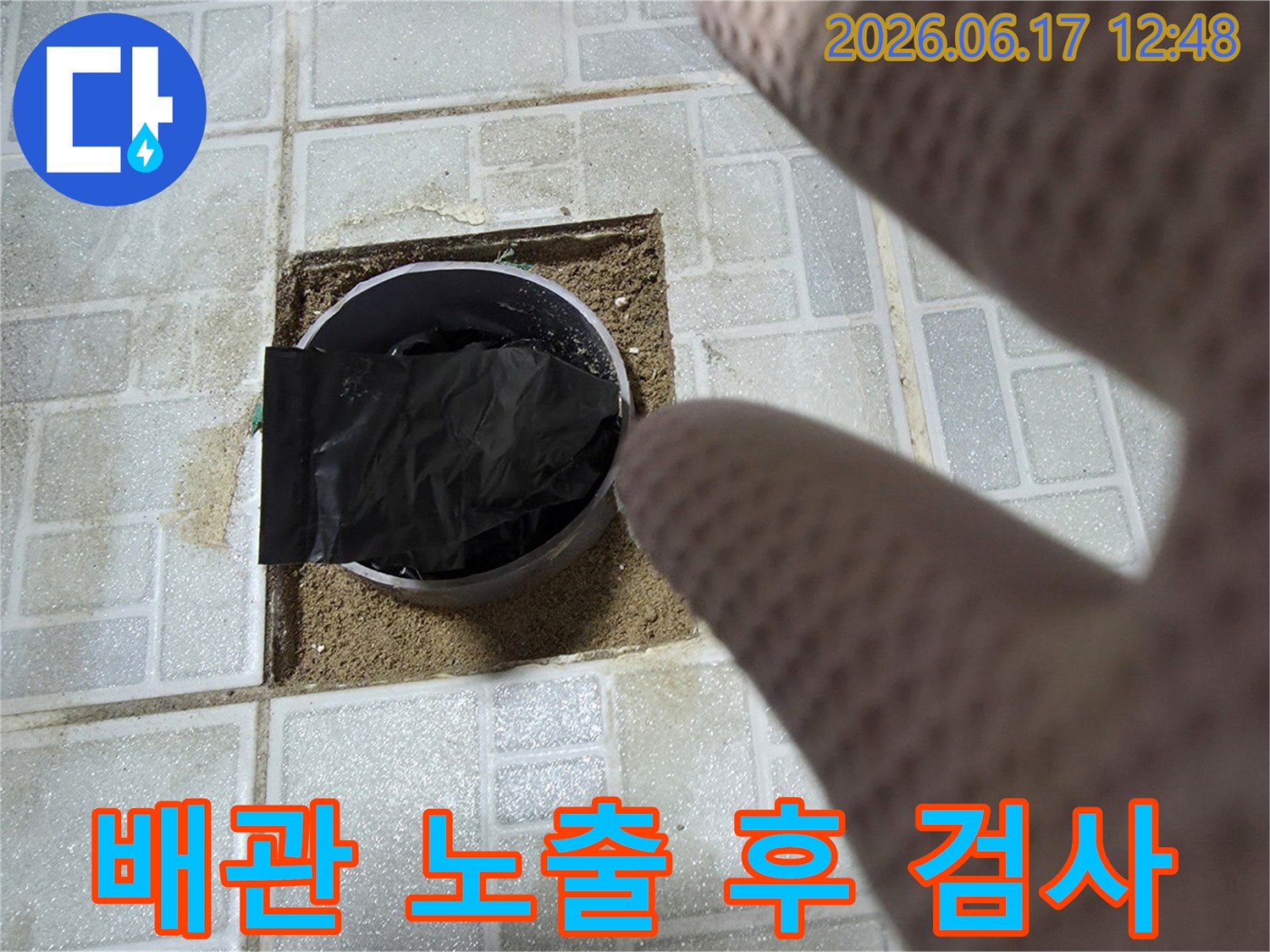 전문 엔지니어가-화장실 바닥 타일-제거 후-노출된 배관을-정밀하게-검사하는-모습