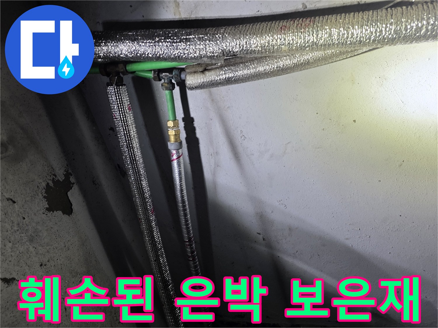 찢어진 은박 보온재 사이로 드러난 금속 배관 연결부