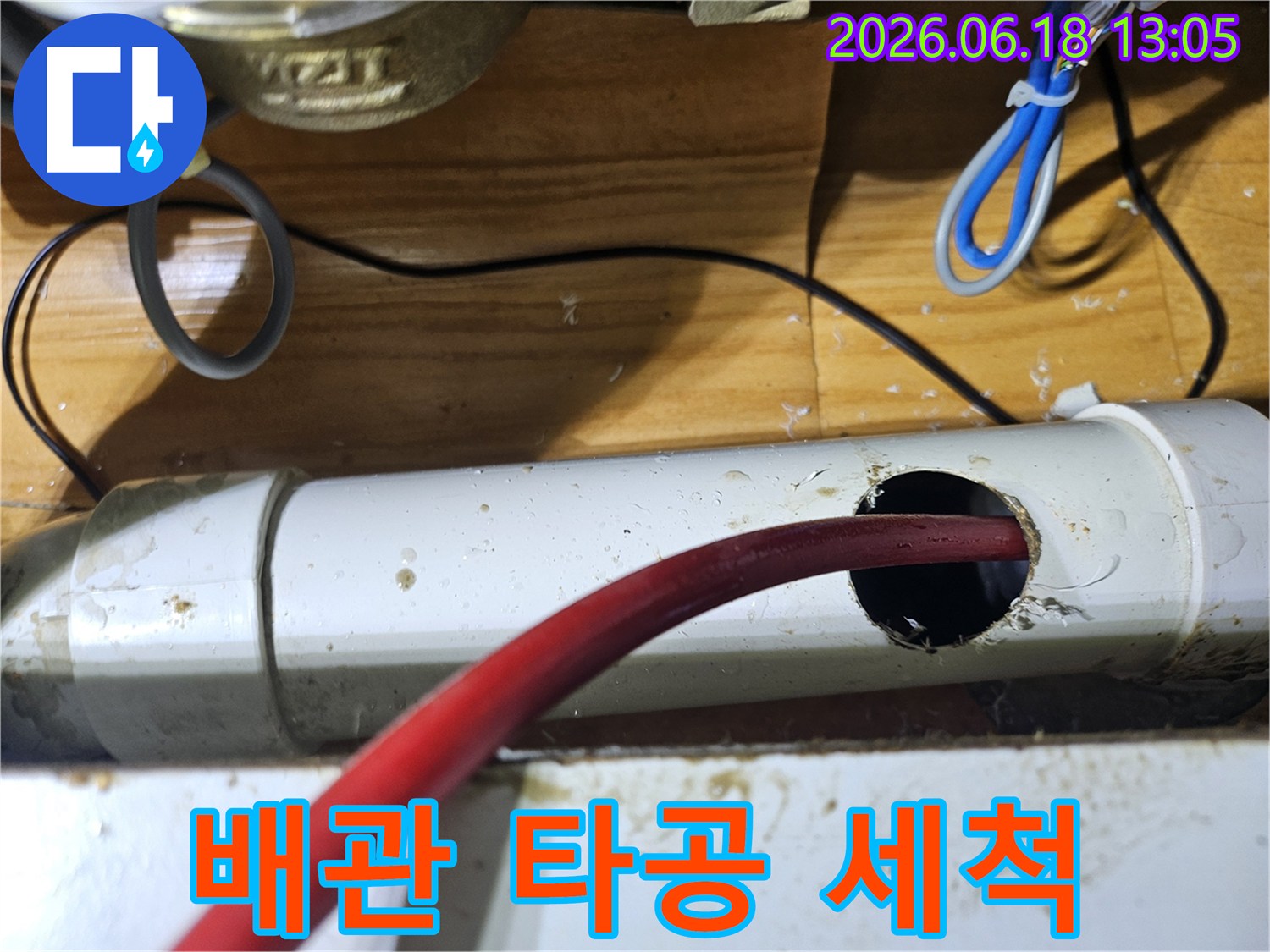 누수 지점을 확인하고-배관에 구멍을 뚫어-내부를 청소하는 모습입니다.
