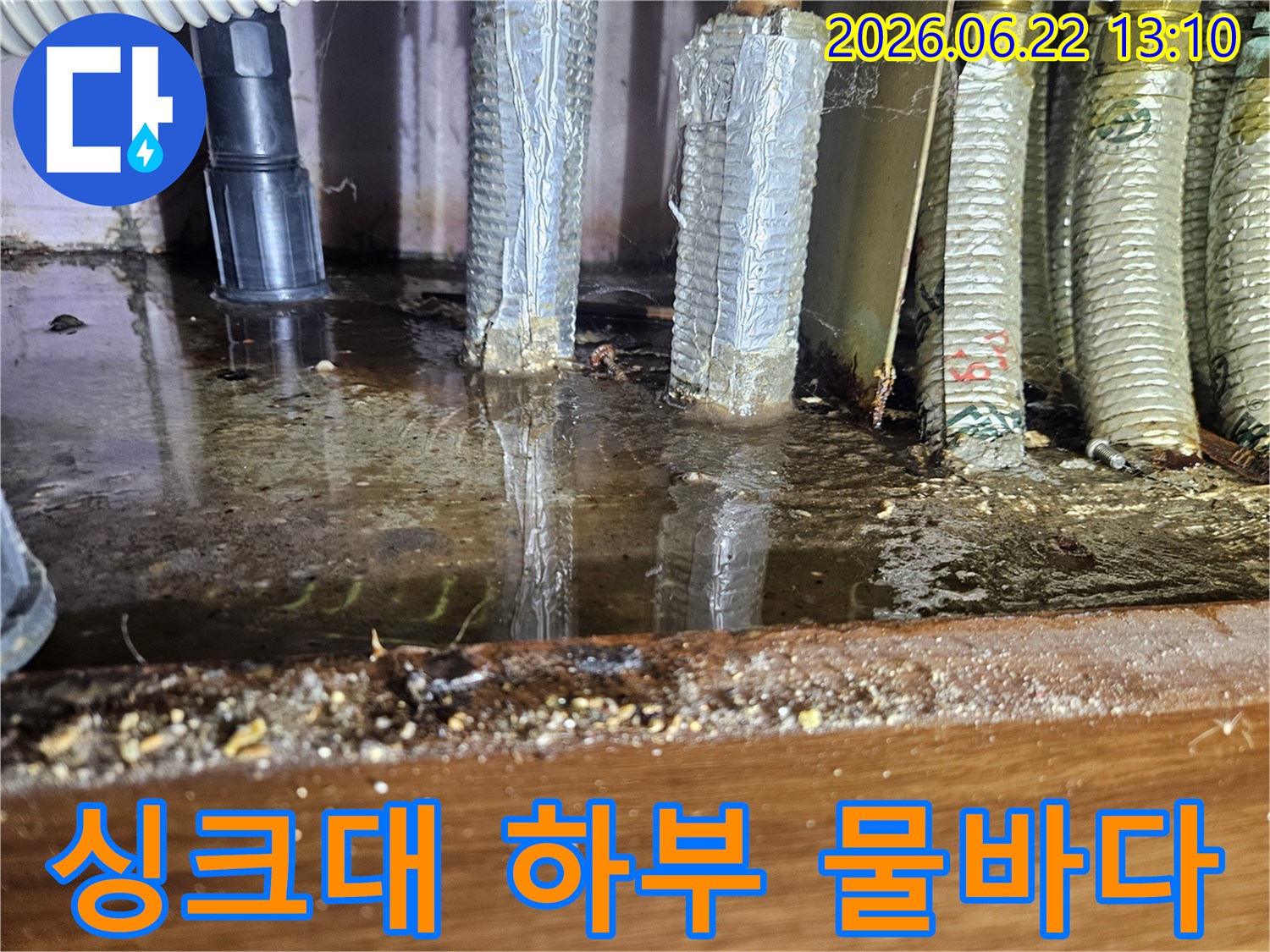 싱크대 아래 공간에 물이 가득 고여-배관이 침수된 심각한 누수 현장입니다.