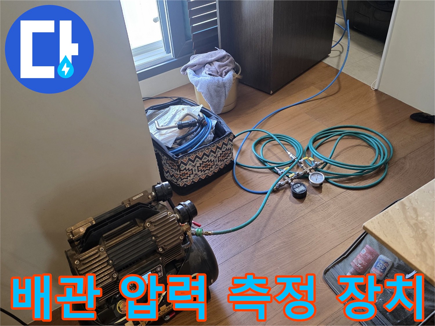 바닥에 놓인 공압 테스트용 게이지와 호스 연결 모습
