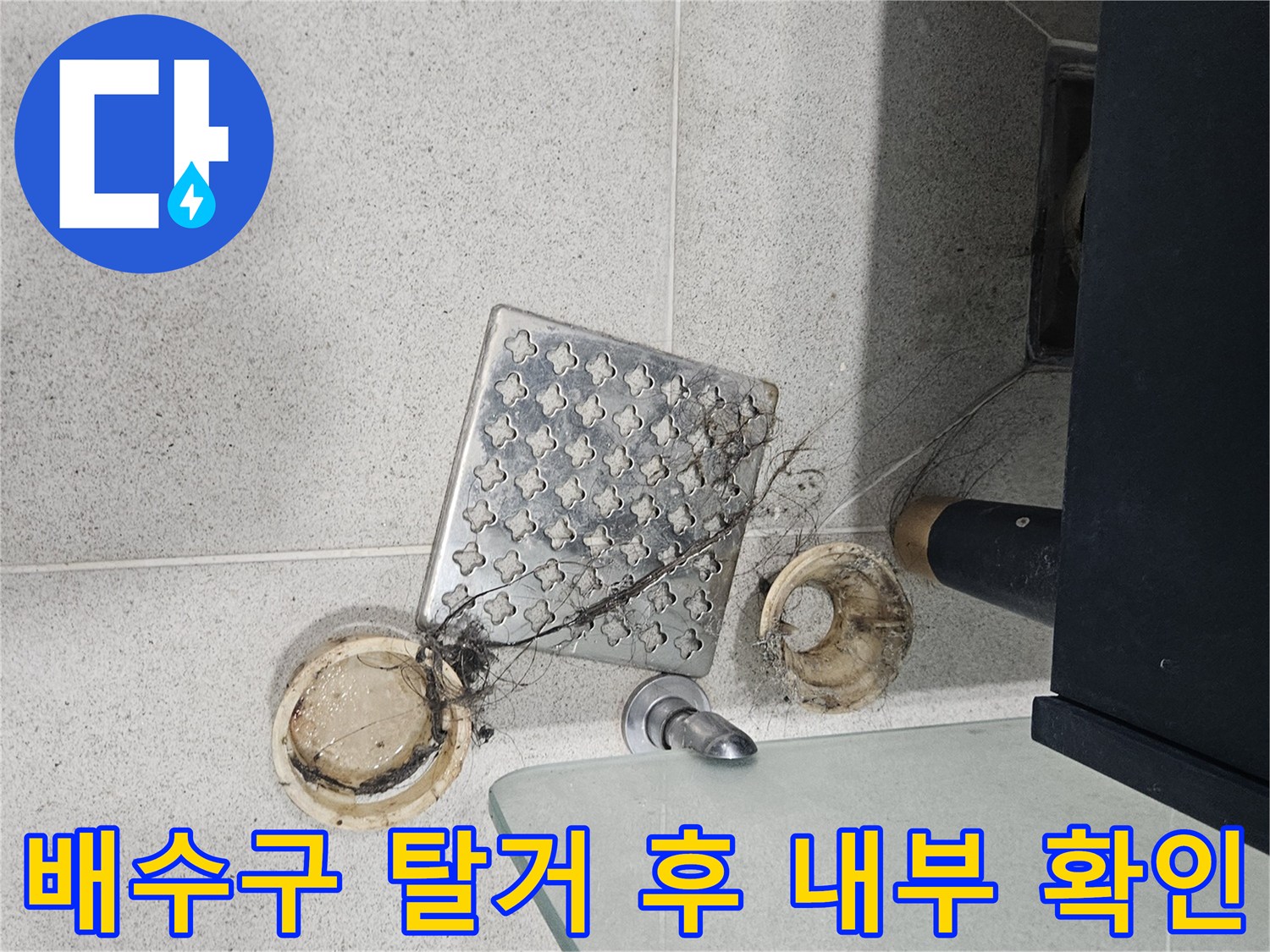 유가 덮개를 제거하여 드러난 배수관 입구와 타일 경계 부분입니다.