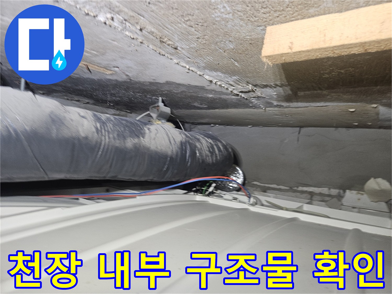 천장 콘크리트 벽면과 검은색 배관의 근접 촬영
