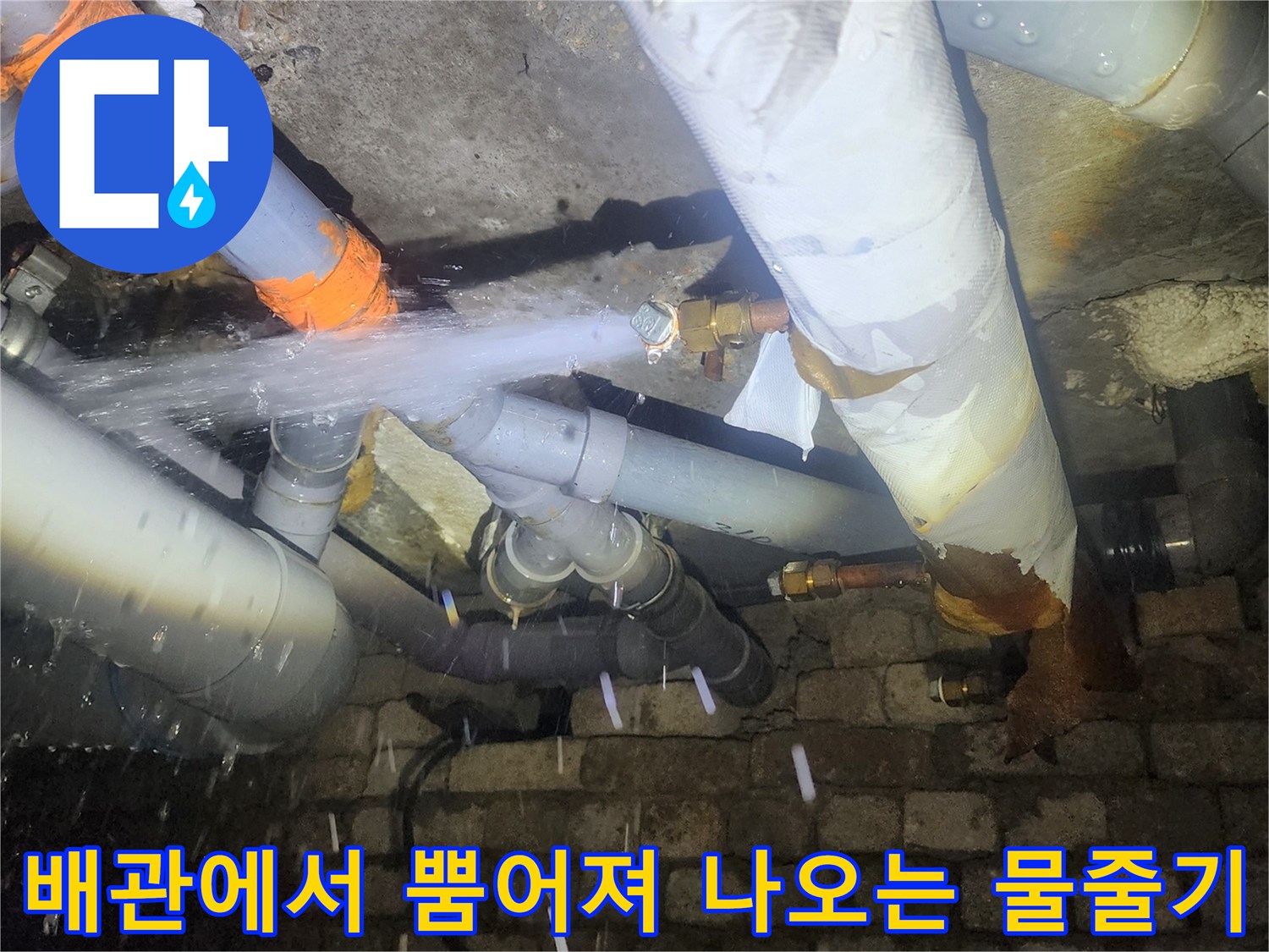 천장 내부 배관 연결부에서 강한 수압으로 물이 새어 나오는 모습
