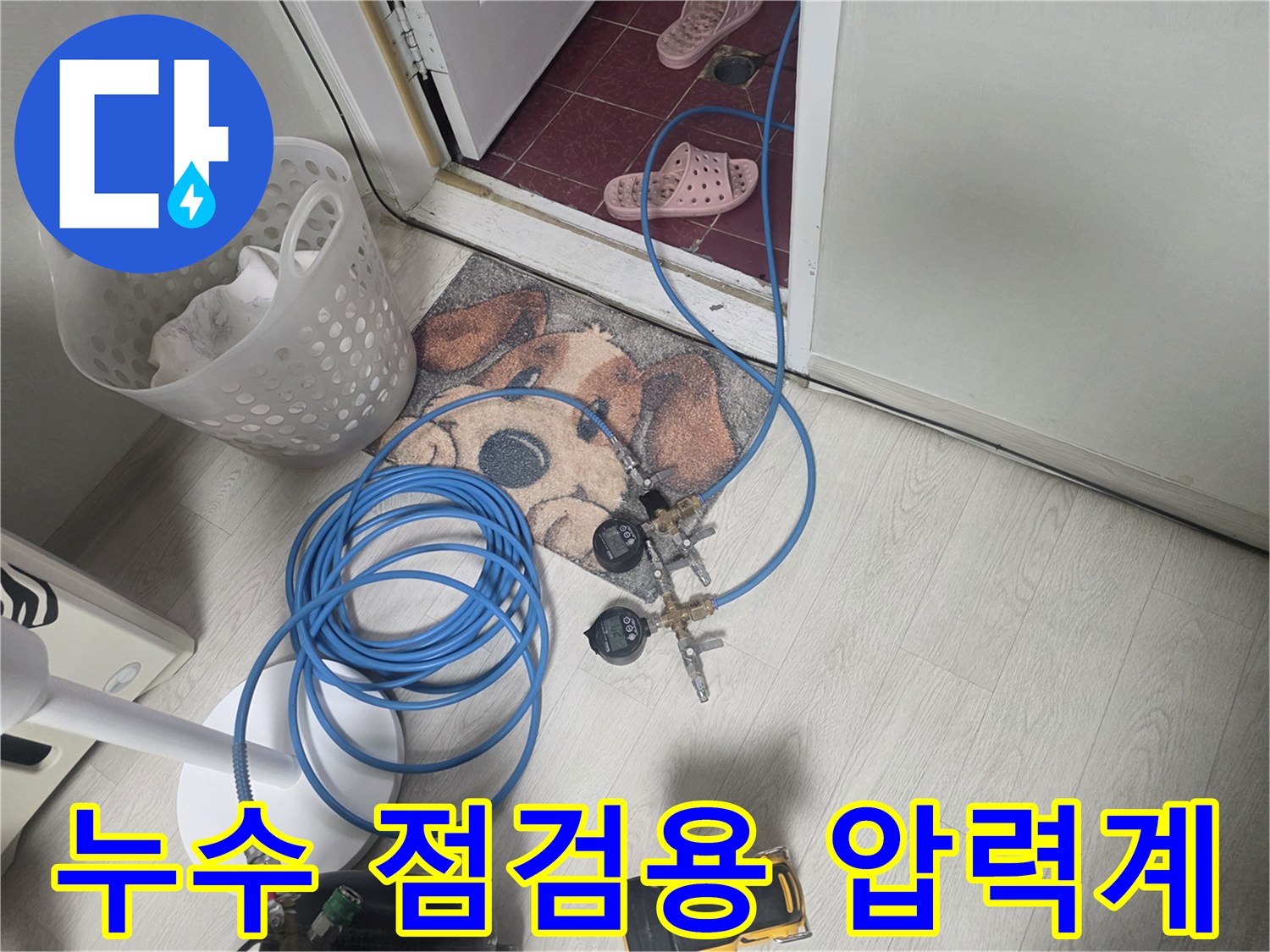 바닥에 놓인-파란색 호스와 연결된-누수 탐지용 게이지