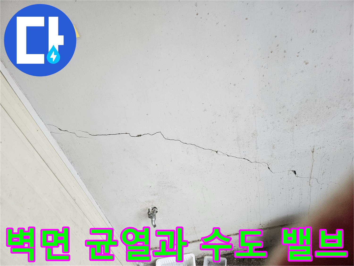 하얀색 벽면에 나타난 크랙과 하단 수도 시설물
