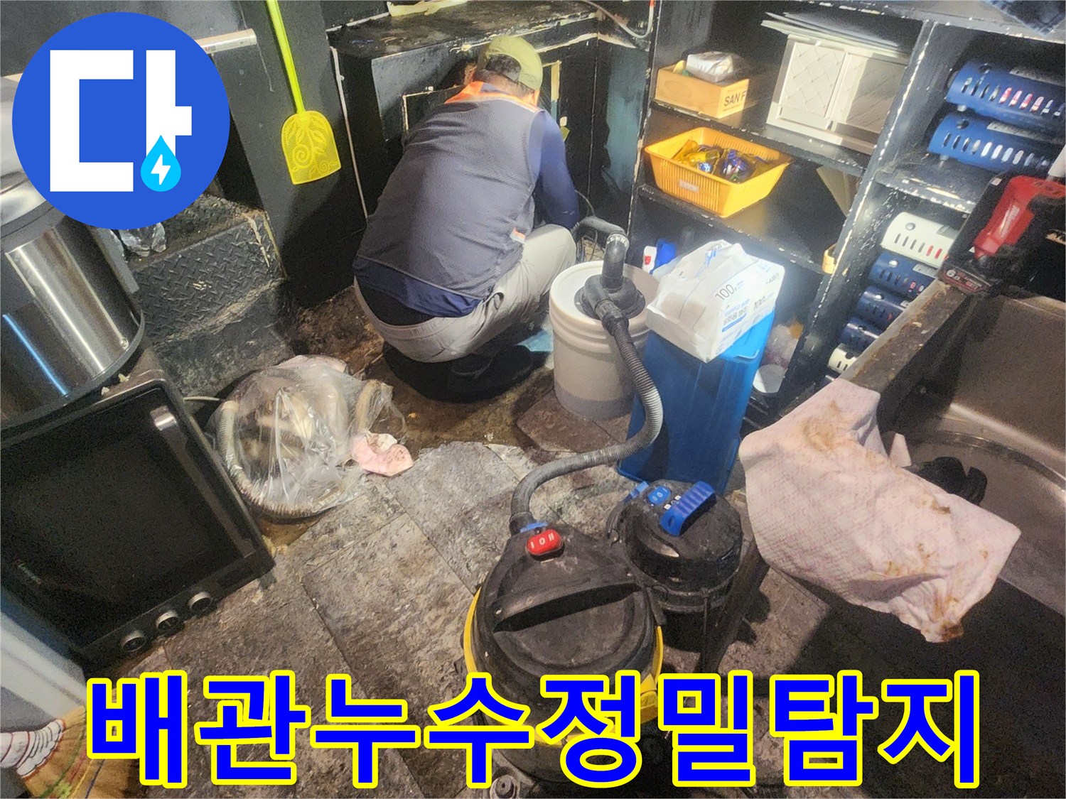 누수-전문가가-복잡하게-얽힌-주방-배관-아래에서-누수-지점을-정밀하게-탐지하는-장면