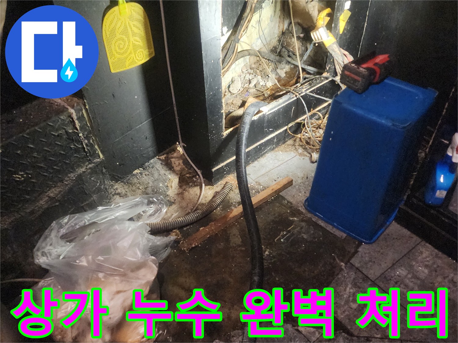 어두운 상가 바닥 아래에서 복잡하게 얽힌 배관과 전선-그리고 물이 새는 흔적을 보여주며 누수 탐지 및 완벽 처리를 진행하는 현장 이미지